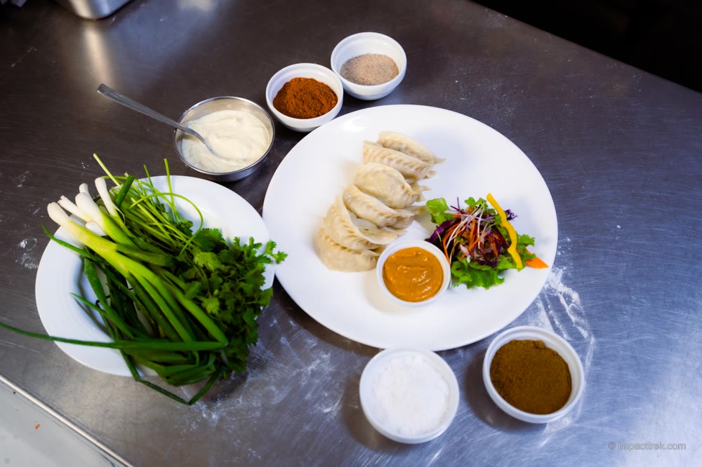 Steamed momo plated with fresh achar dipping sauce