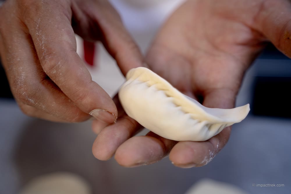 A hand-pleated momo, sealed and ready to steam